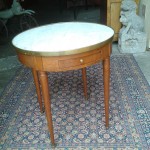 petite table Louis XVI, dite table bouillotte, en bois blond avec deux tiroirs et deux tirettes gainées de cuir. Plateau de marbre blanc.