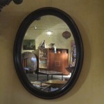 Élégant miroir ovale de taille moyenne, avec encadrement en bois exotique.